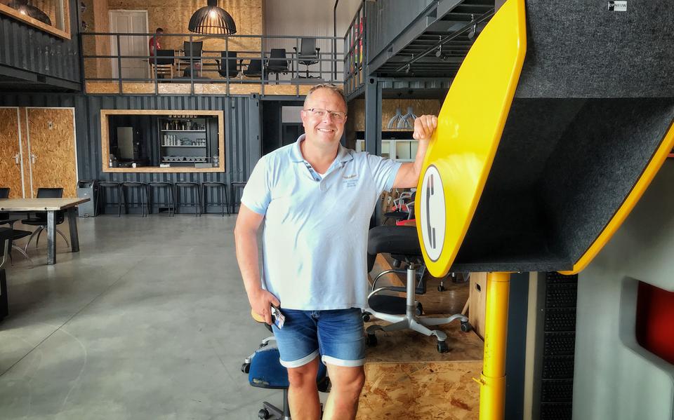 Oprichter Douwe Jan Boersma van circulair bedrijf Opnieuw in Buitenpost, met naast hem een 'akoestische praatpaal' voor wie niet gestoord wil worden tijdens het bellen.