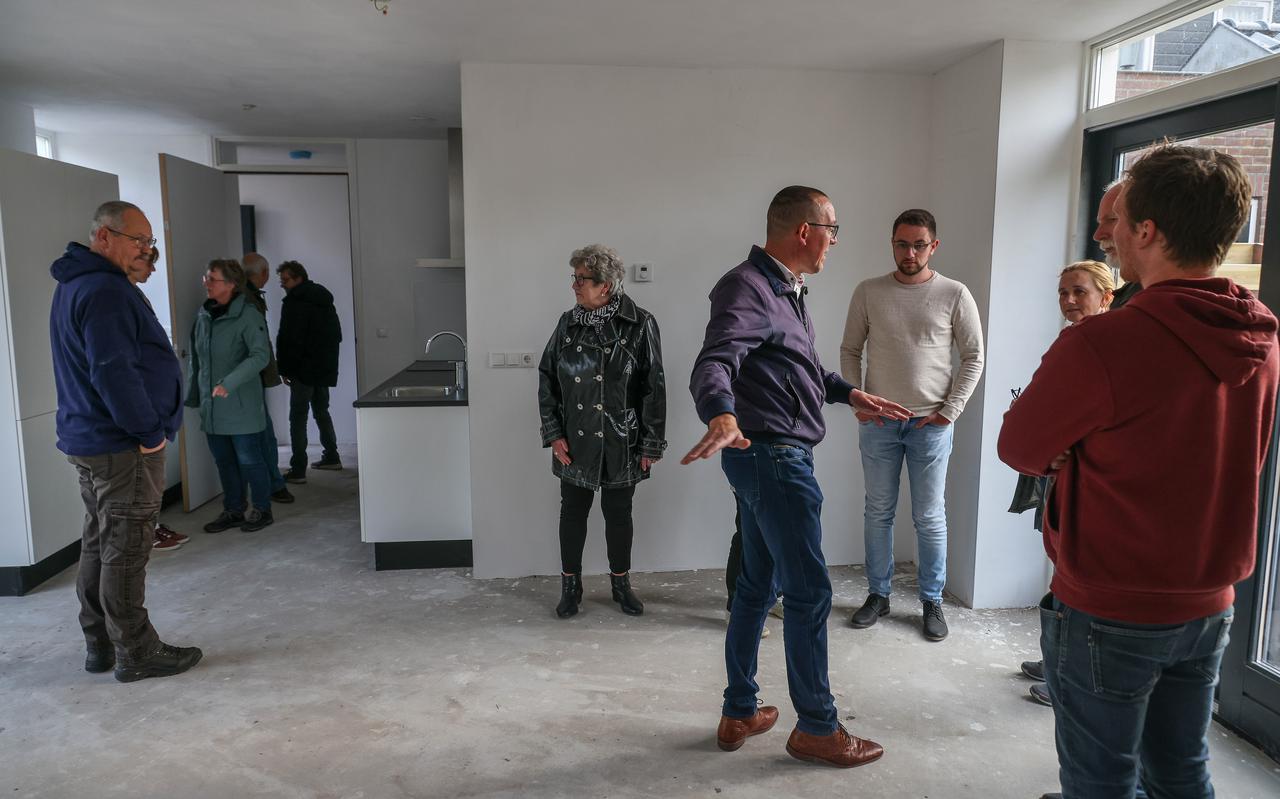 Kerkrentmeester André Buwalda (midden rechts met blauw jasje) geeft belangstellenden uitleg in één van de nieuwe huurwoningen. Tegenover hem toekomstig bewoner Tom Beuker (met witte trui en bril).