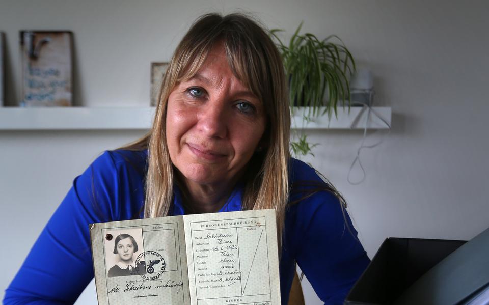 Sue Smeding met in haar hand het paspoort van haar moeder en en daaronder het rekenschriftje uit de oorlog.