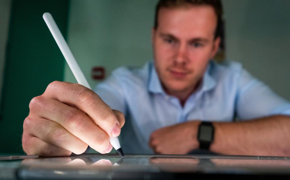 Marc Tuinier met in zijn hand een Apple Pencil met daarop het door hem ontwikkelde zwarte puntje.