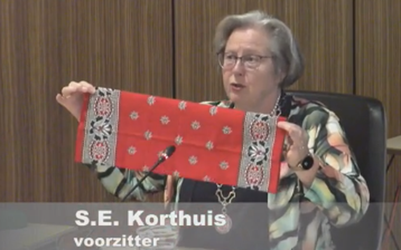 Fokke Hut biedt een rode boerenbonte protestzakdoek aan burgemeester Sandra Korthuis aan.