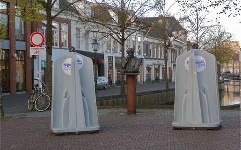 Het beeld van Wim Duisenberg in het centrum van Heerenveen. In het verleden, in dit geval in 2017, stonden er ook al eens twee grote urinoirs naast het beeld. 