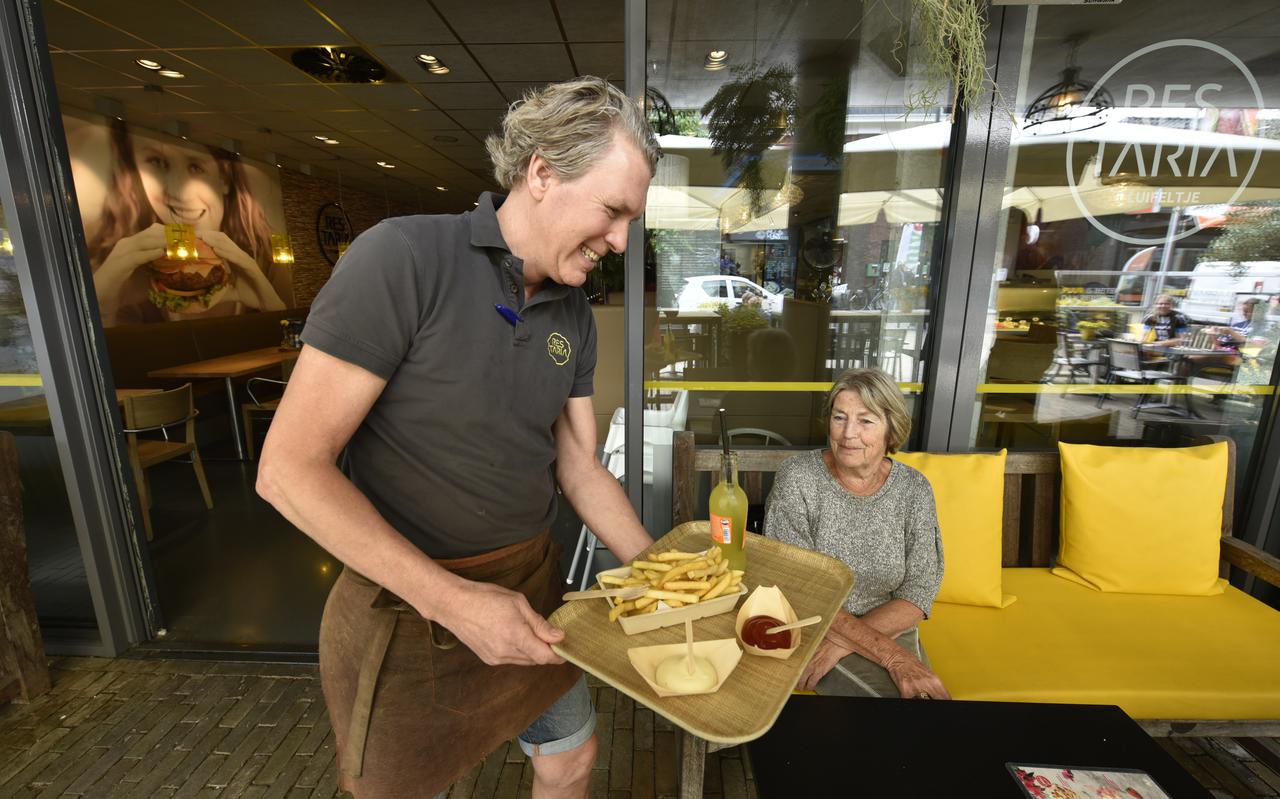 Bauke van der Meer serveert Esther Keizer patat en saus in bakjes van bamboe. Bauke van der Meer serveert Esther Keizer patat en saus in bakjes van bamboe.