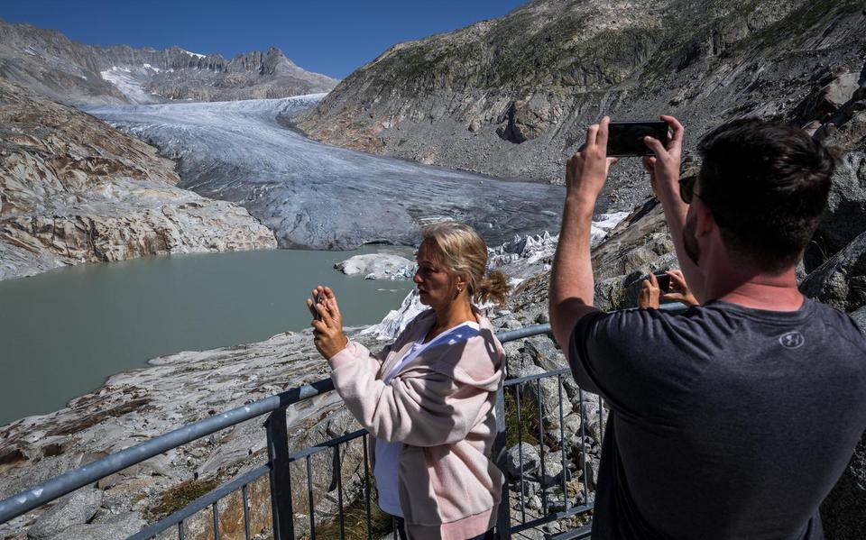 Toeristen fotograferen de Rhônegletsjer in Zwitserland. Door klimaatopwarming signaleerden wetenschappers dat die vorig jaar in recordtempo smolt.