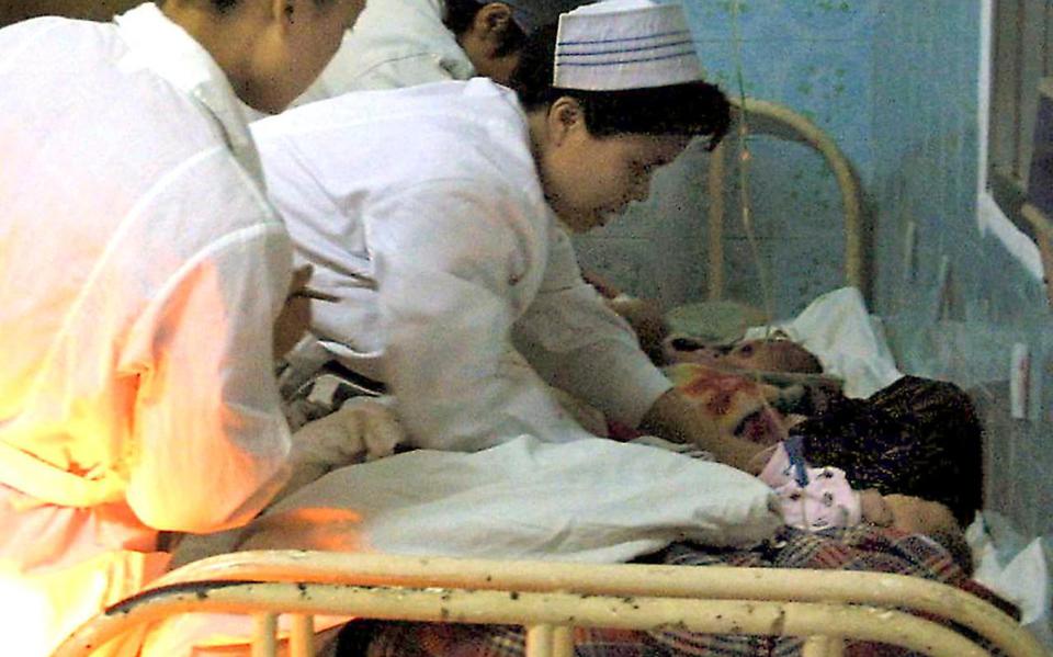 Medisch personeel ontfermt zich over enkele baby’s die uit handen van kinderhandelaren zijn gered, in de Chinese stad Nanning in 2003.