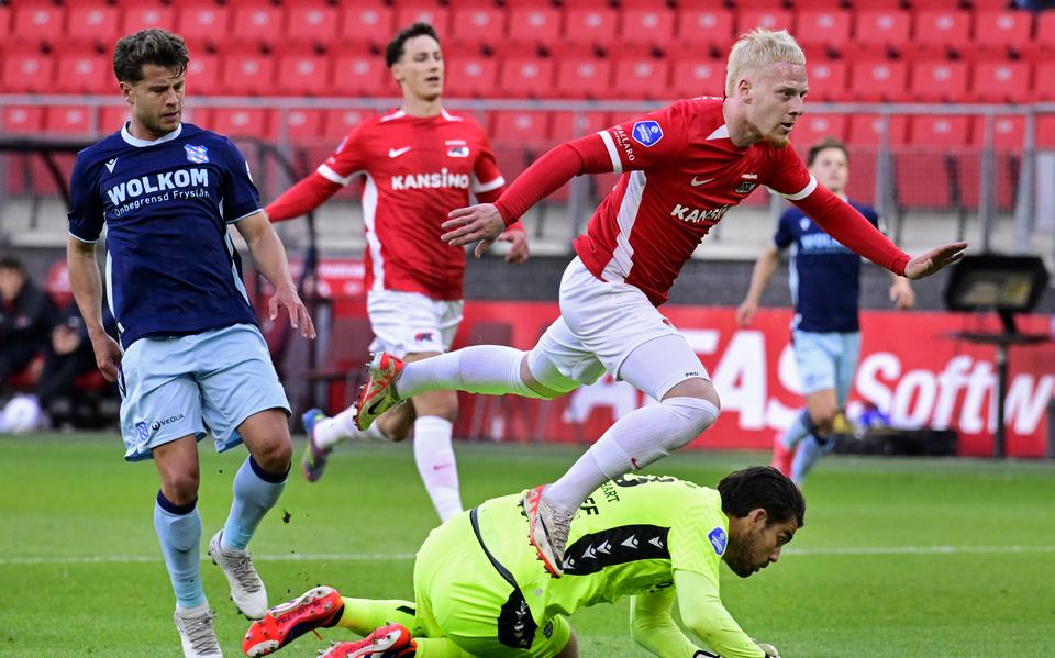 AZ-aanvaller Mexx Meerdink schiet de 2-0 binnen tegen SC Heerenveen. Mats Köhlert en Mickey van der Hart zijn te laat.