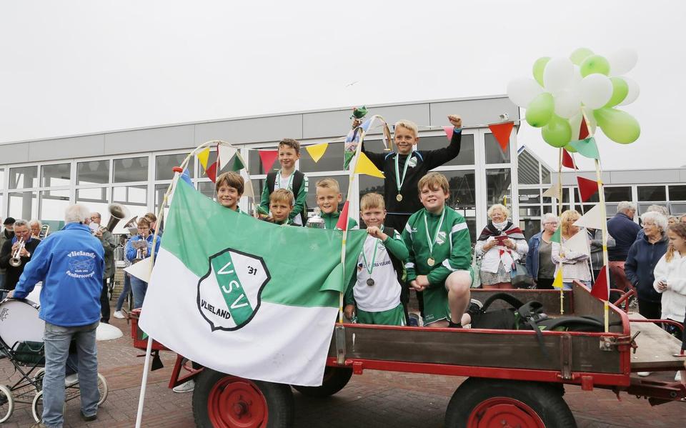 De eerste officiële voetbalkampioenen van VSV ‘31 JO-10 worden bij terugkeer op Vlieland als helden onthaald. FOTO VLIELANDFOTO