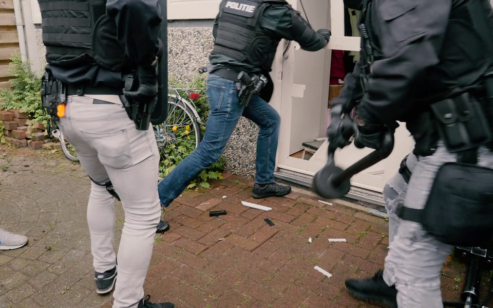 Een aanhoudingseenheid van de politie gaat de woning binnen van een verdachte in de zaak Tuimelaar.