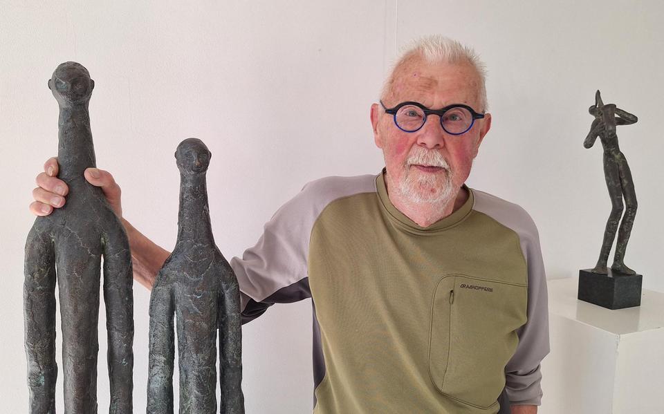 Kunstenaar Jitse Sikkema naast enkele kunstwerken van zijn hand.