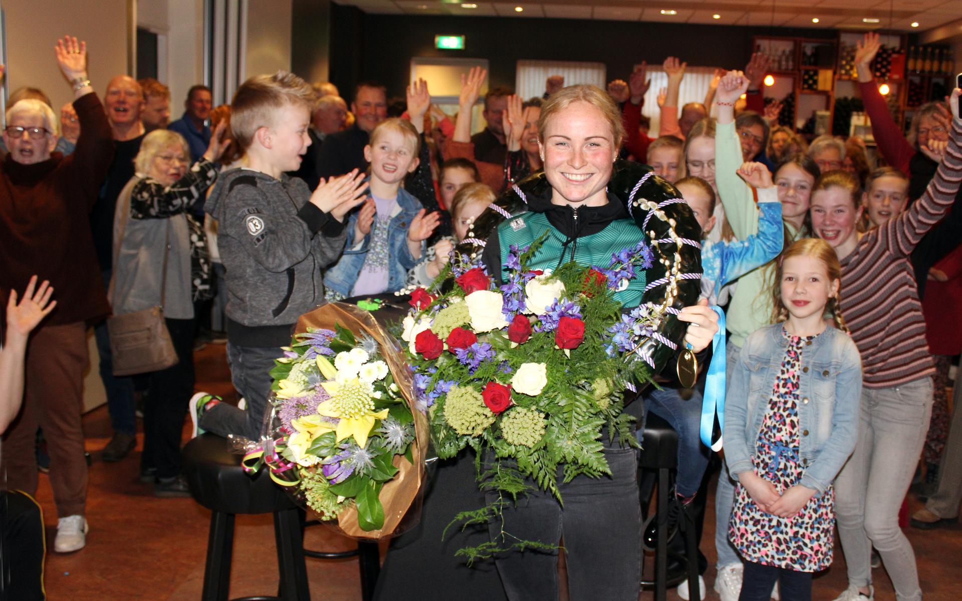 Jong en oud komt naar mfc Trefpunt in Hallum om ‘ús’ Marijke Groenewoud toe te juichen, in de bloemen te zetten en te feliciteren met haar wereldtitel in de massastart op de schaats. 